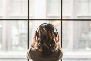 woman listening to music in front of window