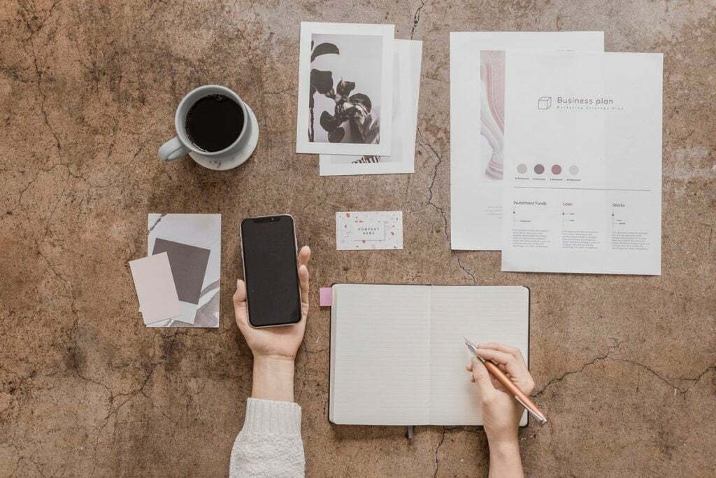 woman creating planner with coffee and iphone