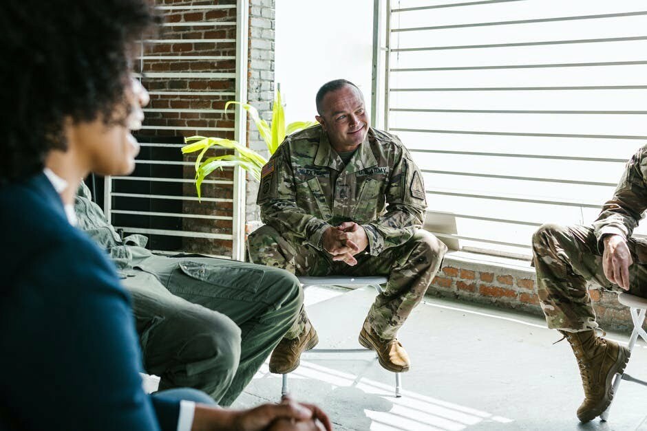 A group of military people discussing PTSD treatment